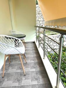 a balcony with a white chair and a table at Rooms with view in Himare