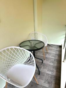 two white chairs and a table and a table and chairs at Rooms with view in Himare
