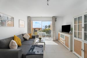 een woonkamer met een bank en een televisie bij casa agua y sol 2 in Poris de Abona