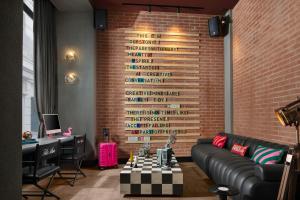 a room with a couch and a brick wall at Moxy Istanbul Taksim by Marriott Bonvoy in Istanbul