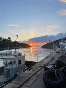 a boat is docked at a dock with the sunset at Ty Dahouet Bretagne in Pléneuf-Val-André