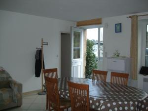 a dining room with a table and chairs and a door at Ty Dahouet Bretagne in Pléneuf-Val-André +2 photos
