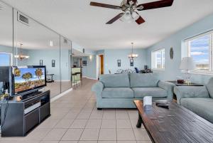 a living room with a couch and a tv at LAG902 Laguna Keys Oceanfront 4BR/3B Condo in Cherry Grove in Myrtle Beach