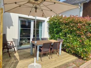 ポルニシェにあるMaison 3 piscines - Résidence 3 étoilesのデッキのパラソル下にテーブルと椅子