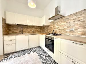 a kitchen with white cabinets and a black and white floor at Casa Miró in Arona