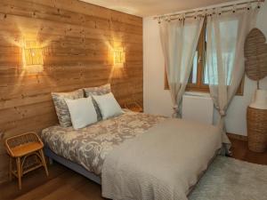 ein Schlafzimmer mit einem Bett und einer Holzwand in der Unterkunft Chalet Toscane avec bain nordique in La Bresse