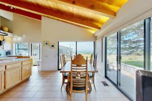 a kitchen with a table and chairs and a view of the ocean at Whale Tales in Gualala