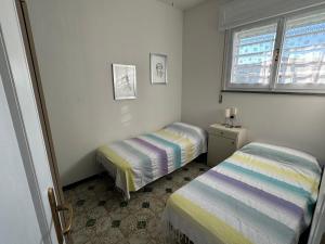 a small room with two beds and a window at Appartamento Gina lido di savio in Lido di Savio