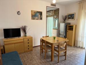 a living room with a table and a television at Appartamento Gina lido di savio in Lido di Savio