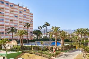 un grande condominio con palme e piscina di Aparartamento Abril a Castillo Bajo