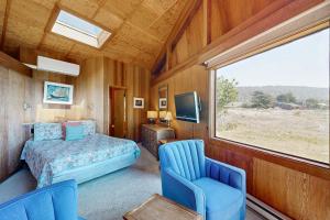 a bedroom with a bed and two chairs and a window at Curtis-Moulton Retreat in Sea Ranch