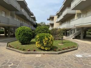 a courtyard of a apartment building with bushes and flowers at Appartamento Gina lido di savio in Lido di Savio