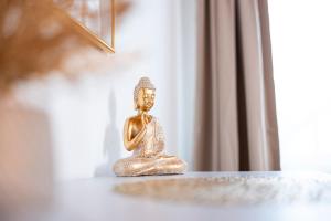 a small golden statue sitting on a table at NAMASTÉ Homes - Ferienwohnung mit Balkon & Carport in Bad Windsheim +14 photos