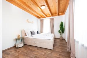 a bedroom with a bed and a wooden ceiling at NAMASTÉ Homes - Ferienwohnung mit Balkon & Carport in Bad Windsheim
