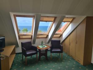 a room with two chairs and a table and windows at Klif Spa in Jarosławiec