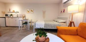 a living room with a bed and a kitchen at מקום להיות סוויטה אדריכלית זוגית in Bet Qeshet +14 photos