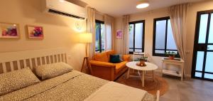 a bedroom with a bed and a chair and a table at מקום להיות סוויטה אדריכלית זוגית in Bet Qeshet