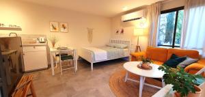 a small living room with a bed and a kitchen at מקום להיות סוויטה אדריכלית זוגית in Bet Qeshet