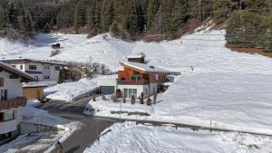 een huis in de sneeuw op een besneeuwde helling bij Apart Silke in Pettneu am Arlberg +34 foto's