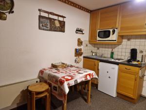 a small kitchen with a table and a microwave at "Montagne Station Prapoutel" Vue Panoramique in Les Adrets