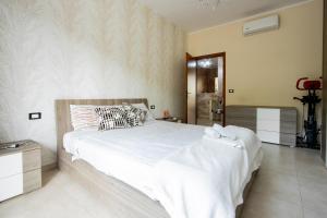 a bedroom with a large bed with white sheets at [Reni House]-Bright apartment+free park in Turin