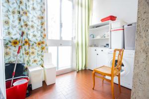 a bathroom with a washing machine and a chair at [Reni House]-Bright apartment+free park in Turin