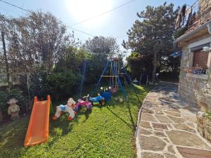 a yard with a playground with toys on the grass at Apartments Baredi in Izola