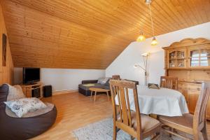 a living room with a table and a couch at Ferienwohnung 'am Park' in Rabenkirchen-Faulück