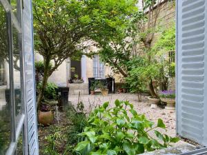 an outside view of a garden with trees and plants at Dépendance calme avec jardin au coeur de Bordeaux in Bordeaux