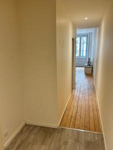 an empty room with a hallway with a wooden floor at Studio au centre ville de Dole in Dole