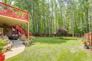 a backyard with a red deck and green grass at Spacious Yard and BBQ Chic Escape in Lawrenceville! in Lawrenceville