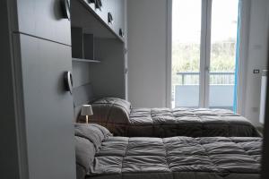 - une rangée de lits dans une chambre avec fenêtre dans l'établissement Magia home, à Caserte 1 autre photo
