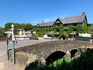a stone bridge over a road in front of a building at Exmoor White Horse Inn in Exford