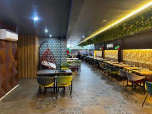 a dining room with tables and yellow chairs at Hotel Legacy in Prayagraj
