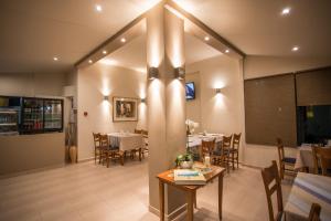 a dining room with tables and chairs in a restaurant at Vasilios Marinos Rooms in Korinthos