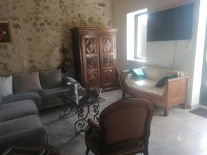 a living room with a couch and a chair at La belle demeure de Margot in Monbazillac