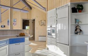 a kitchen with white cabinets and a refrigerator at Holiday Home Hvedemarken in Hejls +13 photos