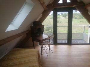 a attic room with a piano and a balcony at La belle demeure de Margot in Monbazillac