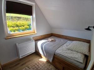 a small bedroom with a bed and a window at Dydusiowe Tarasy Górska Willa z Widokiem i Ogrodem Idealna dla Rodzin in Tylmanowa