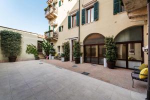 un cortile in un edificio con piante in vaso di PALAZZO RISTORI a Verona