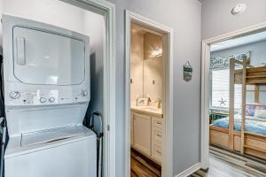 a small kitchen with a refrigerator and a bedroom at AfterDuneDelight by Bolivar Escapes in Crystal Beach +52 photos