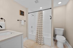 a white bathroom with a toilet and a shower at Buckeye Lake Cottage in Buckeye Lake +17 photos