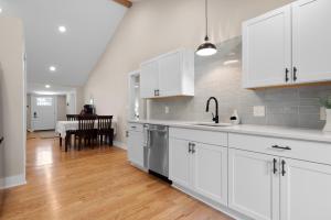a kitchen with white cabinets and a wooden floor at Buckeye Lake Cottage in Buckeye Lake