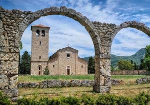 an old stone building with two towers in a field at Casa Nynfa in Castel San Vincenzo
