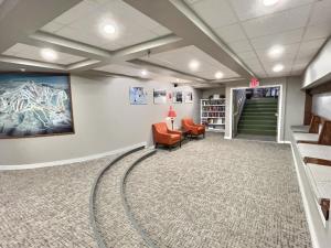 a waiting room with two chairs and a staircase at LilBear- AC, Pool, Sauna, Hot Tub, Near Resort in Killington +26 photos