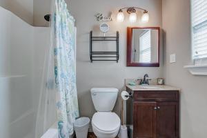 a bathroom with a toilet and a sink and a mirror at Happy Place by Bolivar Escapes in Crystal Beach +26 photos