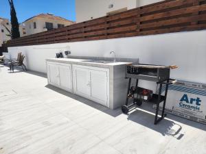 a kitchen with a sink and a grill on a patio at Yama's Villa - Polyxenia luxury, protaras, cyprus in Protaras