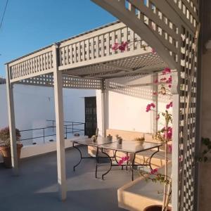a pergola on a patio with a table and chairs at Riad Azama in Azemmour +18 photos