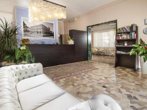 sala de estar con sofá blanco y espejo en New Hotel Chiari en Cervia