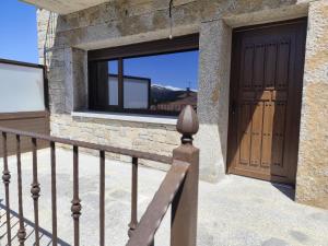 a house with a wooden door and a window at Cumbres y Costumbres de Gredos in Hoyos del Espino